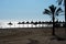 Parasols and palms on Daitona beach, Marbella, Spain.