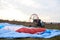 Paratrike with blue parachute ready to fly high in the cloudy sky. Paragliding activity in rural countryside. Weekend leisure time