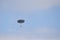 Paratrooper descends with open grey parachute