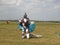 Paratroopers after landing on the ground go through the field and carry their parachutes