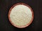 Parboiled rice on bamboo bowl on wood table.