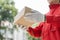 Parcel delivery concept the mailman wearing red uniform and gloves from some logistic companies handing the parcel to a customer