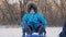 Parent carrying happy little boy on sled in winter. Toddler kid enjoying a sleigh ride. Outdoor fun for family Christmas