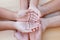 Parent and children holding hands together on wooden background.