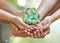 Parent guardian children hands holding together recycled green leaf arrow sign planet on blur nature greenery background sun
