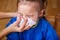 Parent hand helping the girl to blow her nose