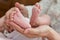 Parent hands gently holding baby feet from below