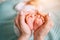 Parent holding in the hands feet of newborn baby.