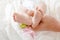 Parent holding in the hands feet of newborn baby.  Tiny newborn baby`s feet on hands closeup. Mom and her child. Happy Family