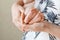 Parent holding in the hands feet of newborn baby.  Tiny newborn baby`s feet on hands closeup. Mom and her child. Happy Family