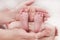 Parent holds gentle little beautiful feet in a newborn baby