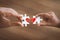 Parent and kid hands connecting couple jigsaw puzzle with drawn red heart