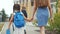 Parent leads to school child with backpack back view. kids go to school with backpacks education concept. mom leads