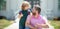 Parent and pupil of primary school with thumbs up sign. Teacher in t-shirt and cute schoolboy with backpack near school