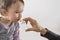 Parent\'s hand of a girl applies a nasal spray to her