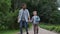 Parent take child to school. Pupil of primary school go study with backpack outdoors. Father and son go hand in hand