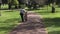 Parent teaching a child to how to ride bicycle without stabilisers in the park