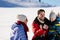 Parenthood, fashion, season and people concept - happy family with child on sled walking in winter outdoors