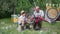 parenting, caring elderly man with boy in hat have fun and repair bicycle wheel while sitting in garden in summer