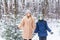 Parenting, fun and season concept - Happy mother and son having fun and playing with snow in winter forest