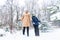 Parenting, fun and season concept - Happy mother and son having fun and playing with snow in winter forest