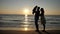 Parents and baby silhouettes, father rising up child, sunrise over sea