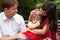 Parents calm crying girl on walk in summer garden