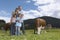 Parents with children (7-9) embracing in field with cows portrait