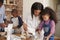 Parents And Children Baking Cakes In Kitchen Together