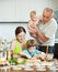 Parents with children dumplings fish cooking in a home kitchen