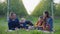 Parents with children enjoys joint pastime in apple orchard eating ripe healthy fruits during picnic in garden in