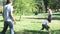 Parents and children playing baseball in a park