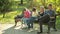 Parents with children sitting on the bench and use mobile smartphones