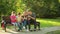 Parents with children sitting on the bench and use mobile smartphones