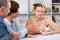 Parents are comforting the upset adult daughter at the table