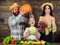 Parents and daughter celebrate harvest holiday pumpkin vegetables fruits. Family farmers with harvest wooden background