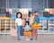 Parents With Daughter Shopping At Supermarket Buying Fresh Grocery Products, Consumerism Concept