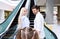 Parents And Daughter Standing On Escalator In Shopping Center