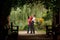 Parents and girl in summer garden in plant tunnel