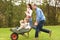 Parents Giving Children Ride In Wheelbarrow