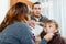 Parents giving medicinal sirup to teenage