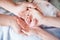 Parents hands hold in their hands the legs of their child on a white background, parental love and tenderness