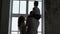 Parents hold hands. The son sits on the father`s shoulders. Family silhouettes at a window. The family has bought the