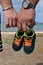 Parents Holding Baby Shoe on Beach