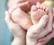 Parents holding feet of his newborn son