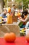 Parents And Kids Carve Pumpkins In A Public Park