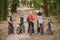 Parents and kids cycling on forest trail. family in warm clothes cycling autumn park. Family mountain bike on forest. active