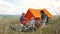 Parents and kids having a picnic and they are going to stay overnight in a tent. Traveler woman and children relaxing