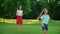 Parents and kids playing with ball in green meadow. Boy and girl jumping in air