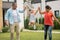 Parents lifting their lovely funny daughter outside near house